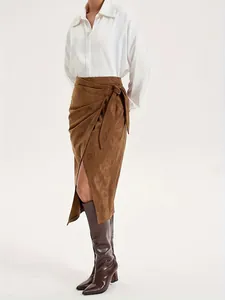 Detailed view of brown suede texture on a wrap midi skirt with tie-knot and front slit