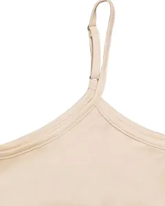 Close-up of adjustable shoulder strap and neckline of a beige camisole dress.