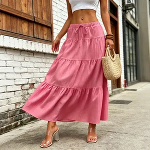 Detail view of a pink tiered maxi skirt with drawstring waist in a street setting
