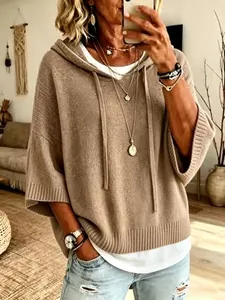 Detail shot of a casual tan women's hooded knit sweater with drawstrings and soft texture.
