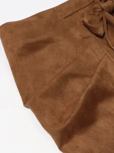 Close-up of brown suede skirt fabric showing fine texture and decorative tie bow
