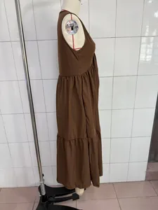 Side profile detail of solid brown sleeveless V-neck tiered maxi dress on mannequin