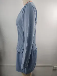 Side view detail of light wash blue denim long sleeve dress on mannequin