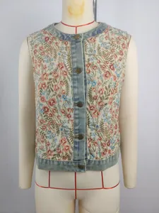 Detailed view of retro floral jacquard vest featuring denim trim and vintage button closure.