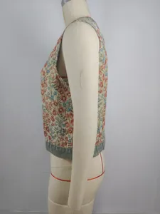Side view detail of a vintage floral tapestry cropped vest featuring a denim hem finish