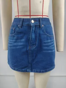 Détail d'une mini-jupe en jean bleue avec moustaches lavées et un bouton métal