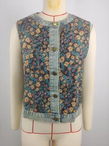 Close-up of retro floral jacquard sleeveless vest with denim trim and metal buttons.