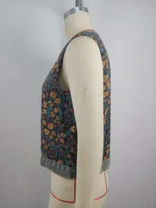 Side view of vintage floral jacquard sleeveless vest with denim trim detail.