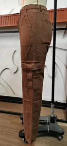 Side view detail of women's brown washed denim cargo pants featuring large side pockets