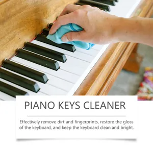 Detalle de un paño de microfibra azul limpiando las teclas blancas y negras de un piano