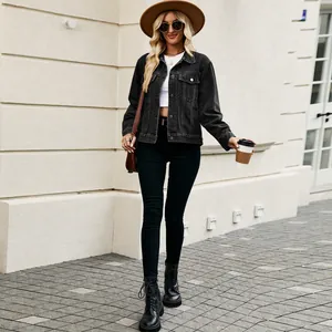 Outdoor lifestyle view of a cropped black denim jacket styled with a brown fedora hat.