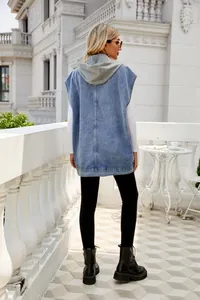 Rear view of a stylish women's light blue denim sleeveless hooded vest on a balcony