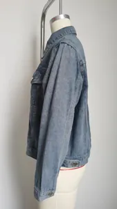 Side profile detail of a slim fit washed blue cropped denim jacket for women.