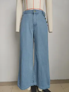 Macro view of light blue wide-leg denim jeans featuring elegant decorative side buttons
