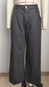 Detail view of high-waist washed grey denim jeans featuring decorative gold buttons.