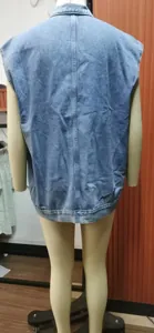 Detailed back view of a light blue washed denim vest presented on a display mannequin