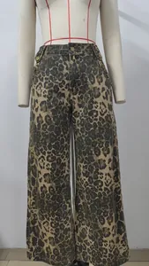 Detailed view of leopard print wide-leg denim pants with vintage side metal buttons.