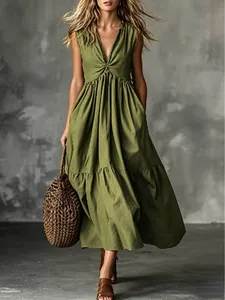 Elegant olive green sleeveless V-neck maxi dress with tiered skirt and brown woven bag