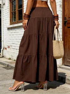 Back view of a brown tiered maxi skirt with vertical textured fabric and a large swing.