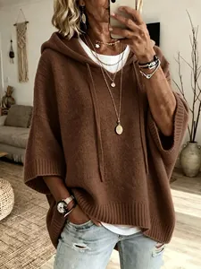Macro view of brown hooded knit poncho sweater showing soft texture and wide sleeves