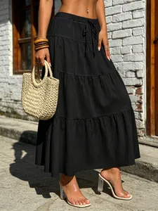 Boho black tiered maxi skirt with elastic drawstring waist and elegant pleated texture.