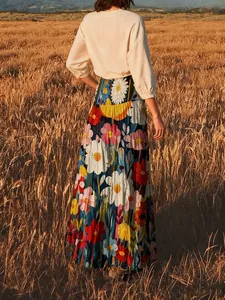 Eleganter Boho-Maxirock mit buntem floralem Ölgemälde-Druck in einem Weizenfeld.