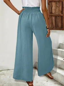 Back view of elegant blue wide-leg trousers with high smocked waist and soft texture.
