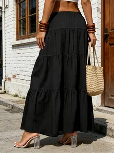Back view of a black tiered maxi skirt with pleated texture and high-waisted design.