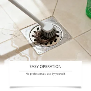 Detail shot of a brush clearing hair from a bathroom floor drain for easy cleaning.