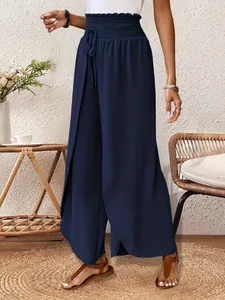 Detail view of navy blue wide-leg trousers with high elasticated waist and split design