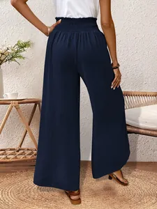 Back view of navy blue wide-leg trousers with elastic high waist and side slit details