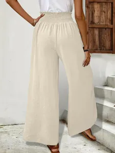 Back view of elegant beige wide-leg pants with crinkled texture and elastic high waist
