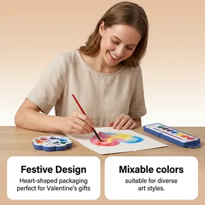 Smiling woman using the heart-shaped watercolor paint set to create a colorful art piece.