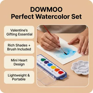 Macro view of heart-shaped watercolor set with a hand using a paintbrush on textured paper
