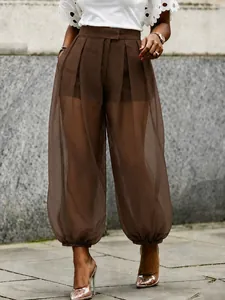 Detail of brown high-waisted sheer mesh lantern pants with elegant cinched cuffs