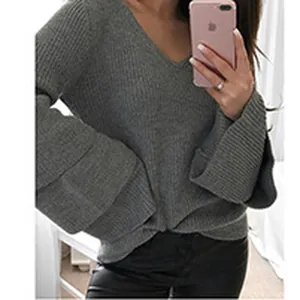 Primo piano di un maglione grigio a maglia con scollo a V e maniche lunghe larghe.
