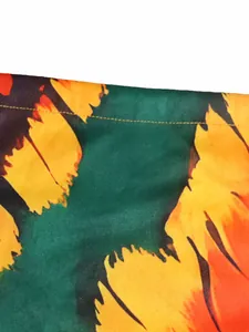 Close-up of vibrant bohemian floral print fabric showing the yellow stitching and texture