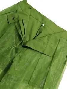 Detail view of high-waisted green sheer mesh pants featuring zipper fly and size S label