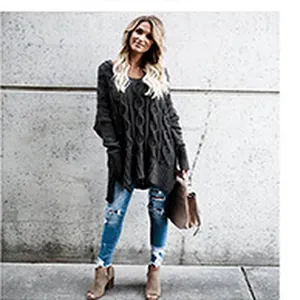 Vista a figura intera di una donna con un maglione oversize a trecce grigio scuro e jeans