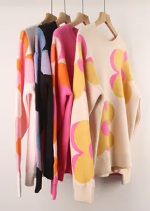 Detailed view of floral print crewneck sweaters hanging in various color options