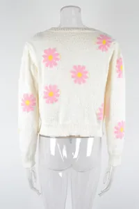 Detailed back view of a white knit sweater featuring vibrant pink daisy floral patterns.