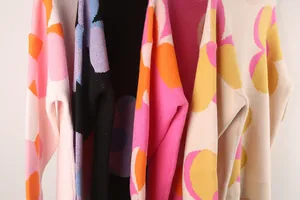Detailed close-up showing vibrant oversized floral patterns on soft knit sweaters