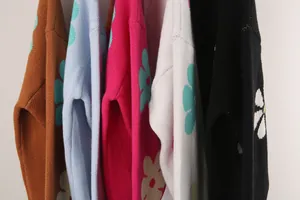 Detailed close-up of knitted sweaters featuring bold floral patterns in various colors