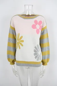 Close-up of color-block knit sweater with floral motifs and striped sleeves