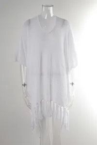 Close-up detail of white hollow-out knit beach cover-up featuring stylish fringe tassels