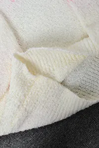 Close-up macro shot showing the soft knitted fabric texture of a daisy sweater detail