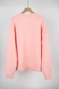 Back view showing the soft knit texture and ribbed hem of the pink crewneck sweater
