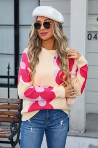 Detailed view of women's round neck knit sweater with bold pink floral patterns.