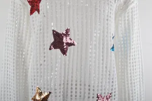 Dettaglio del copricostume bianco in maglia traforata con stelle di paillettes colorate.