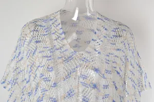 Detalle del cubretodo de playa de punto blanco con cuello en V y patrón de ondas azules